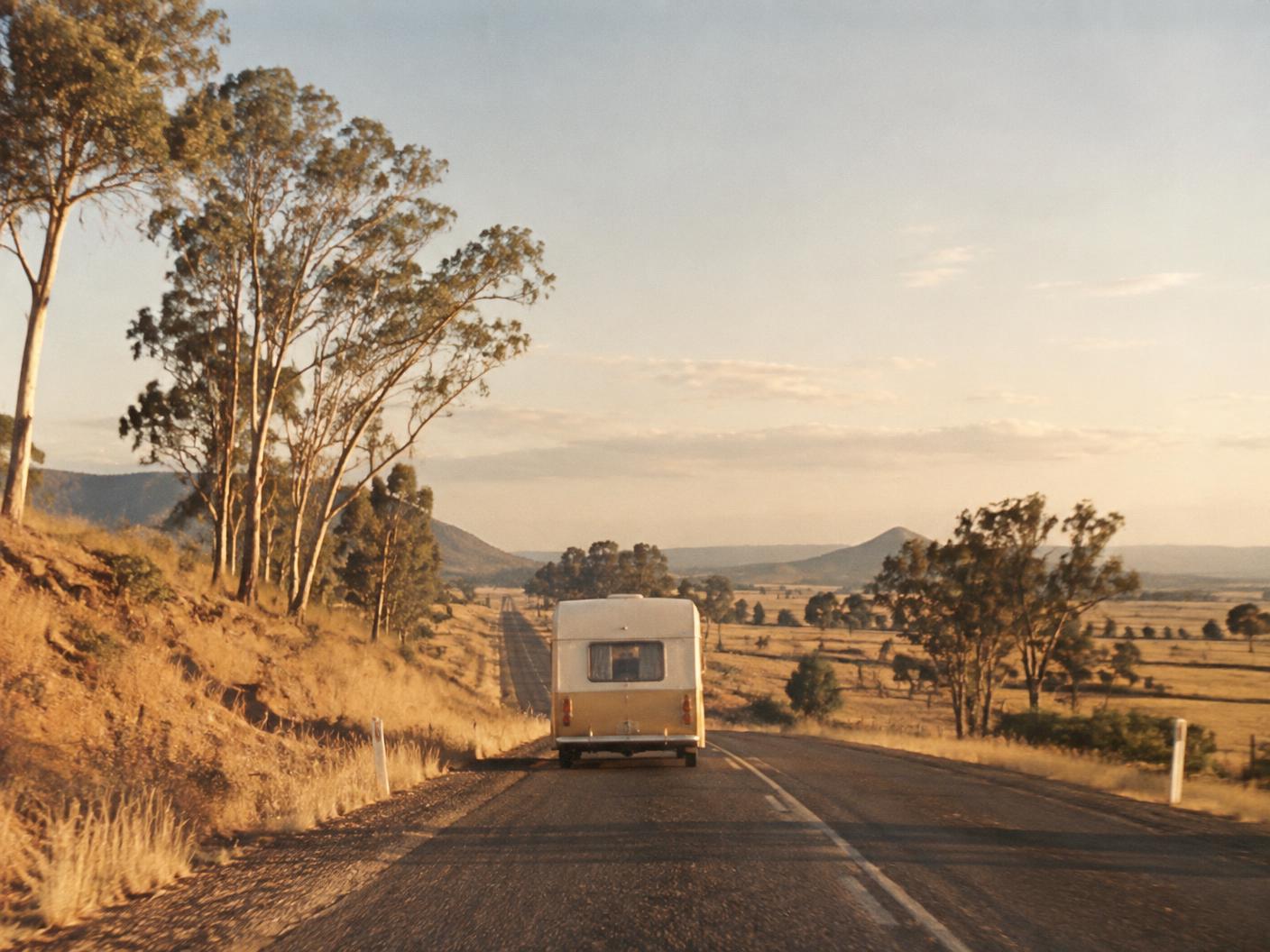 A vintage caravan travelling along an Australian country road